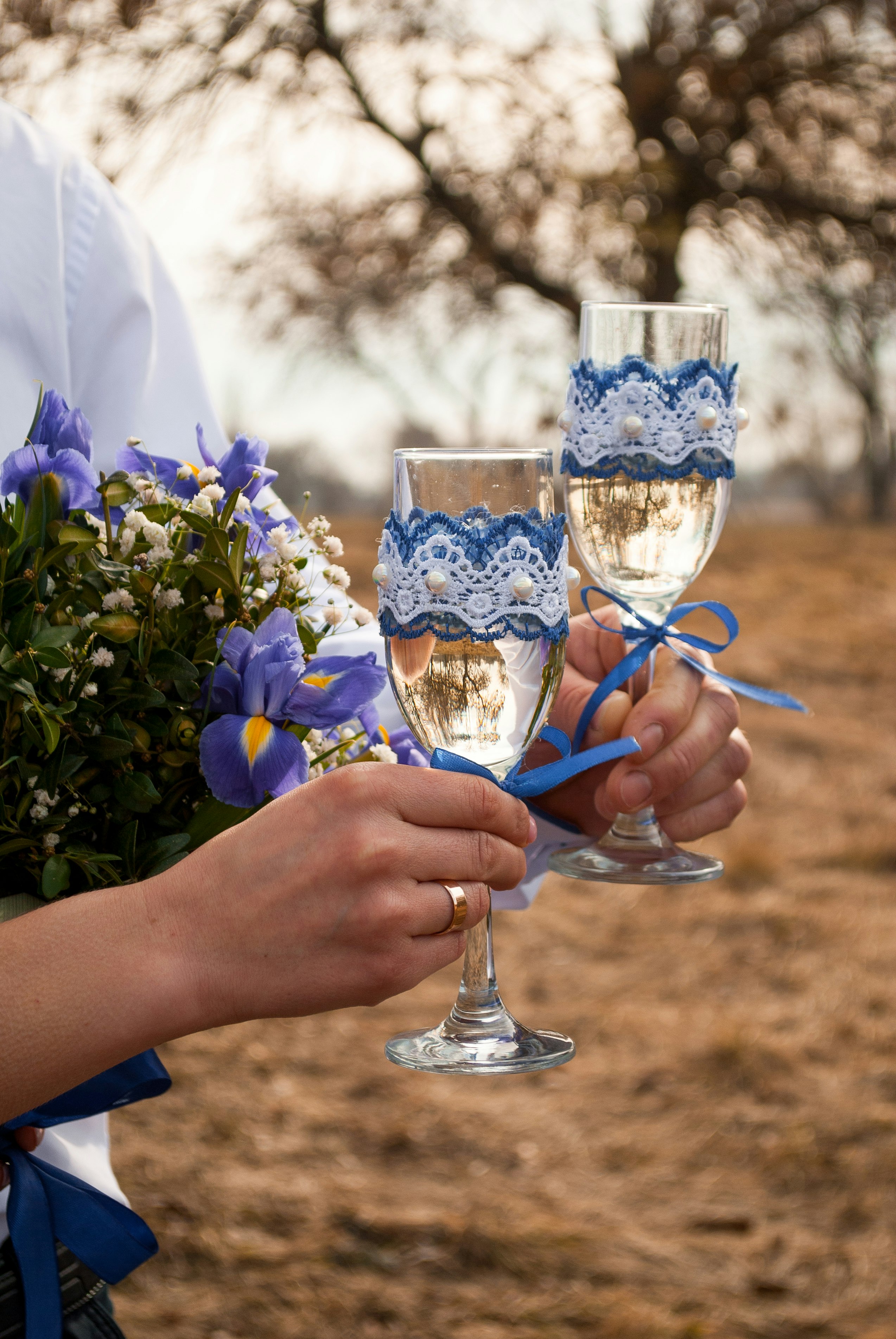 person holding clear wine glass with blue liquid